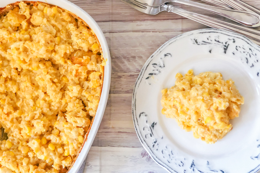 Cheesy Corn Casserole on a plate with main dish beside