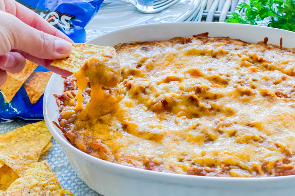 Someone is dunking a chip into our Simple Refried Bean Dip