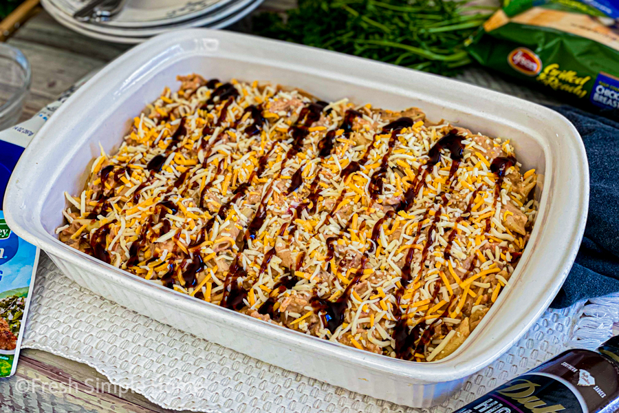 The chicken mixture topped with shredded cheese and drizzled with barbecue sauce right before being cooked. 